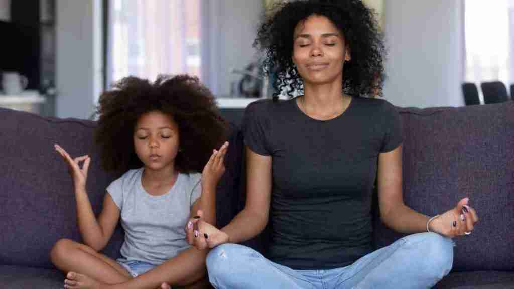 A mother and her daughter meditating together,