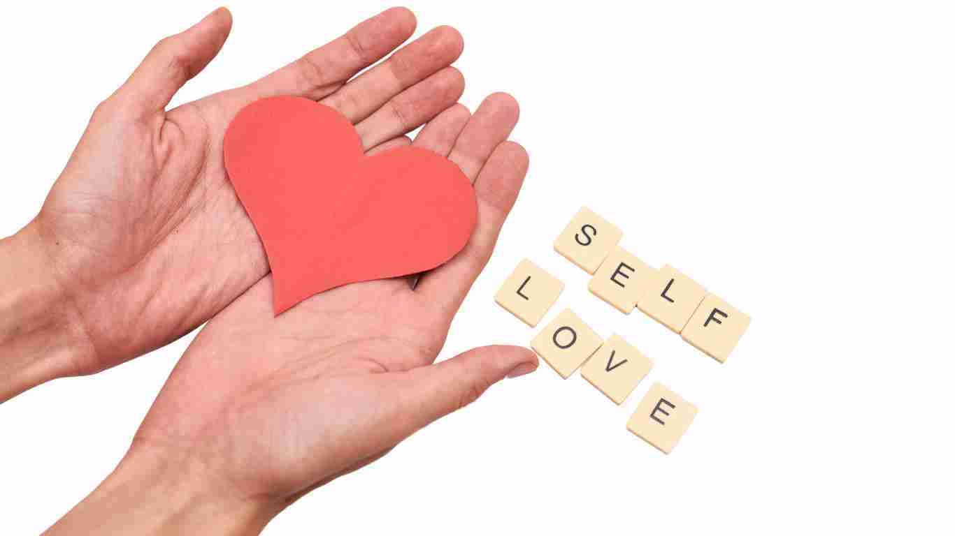 Hands holding a heart and a sign saying SELF LOVE