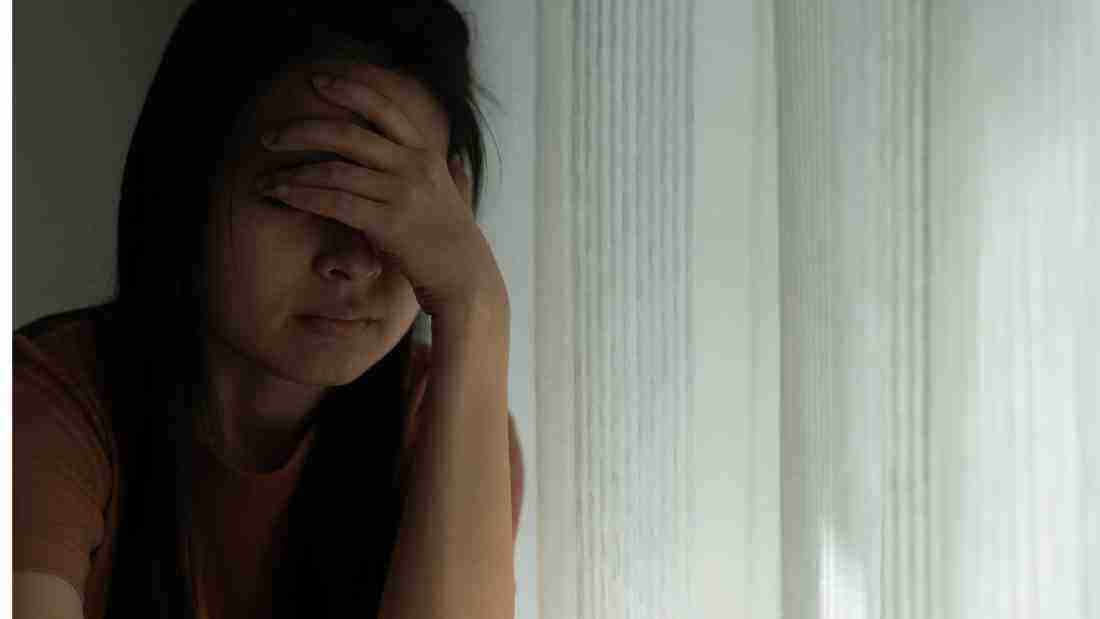 A depressed woman sitting in the dark