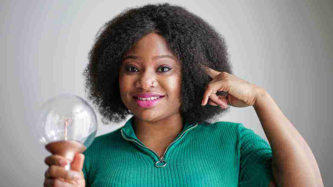 A woman holding a lightbulb