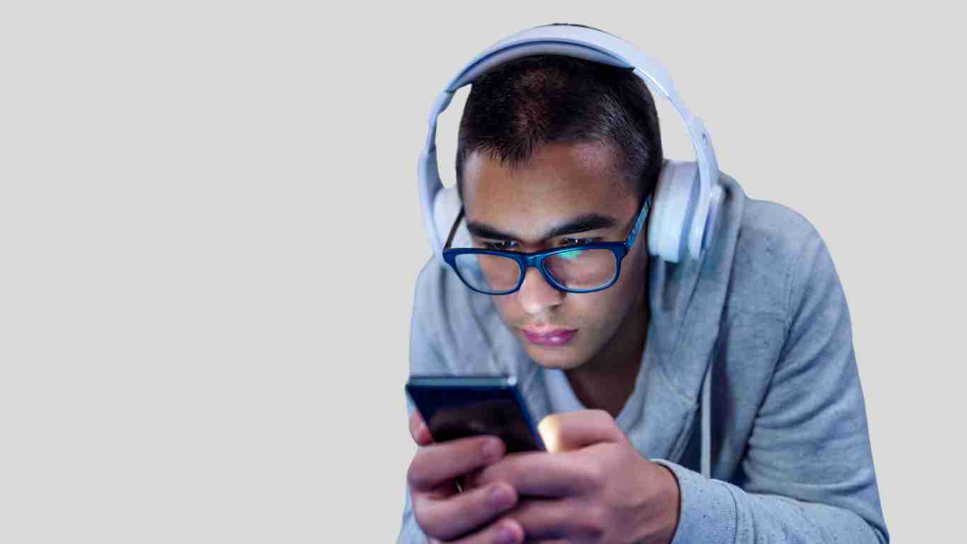 A young man looking concerned as he stares at his phone