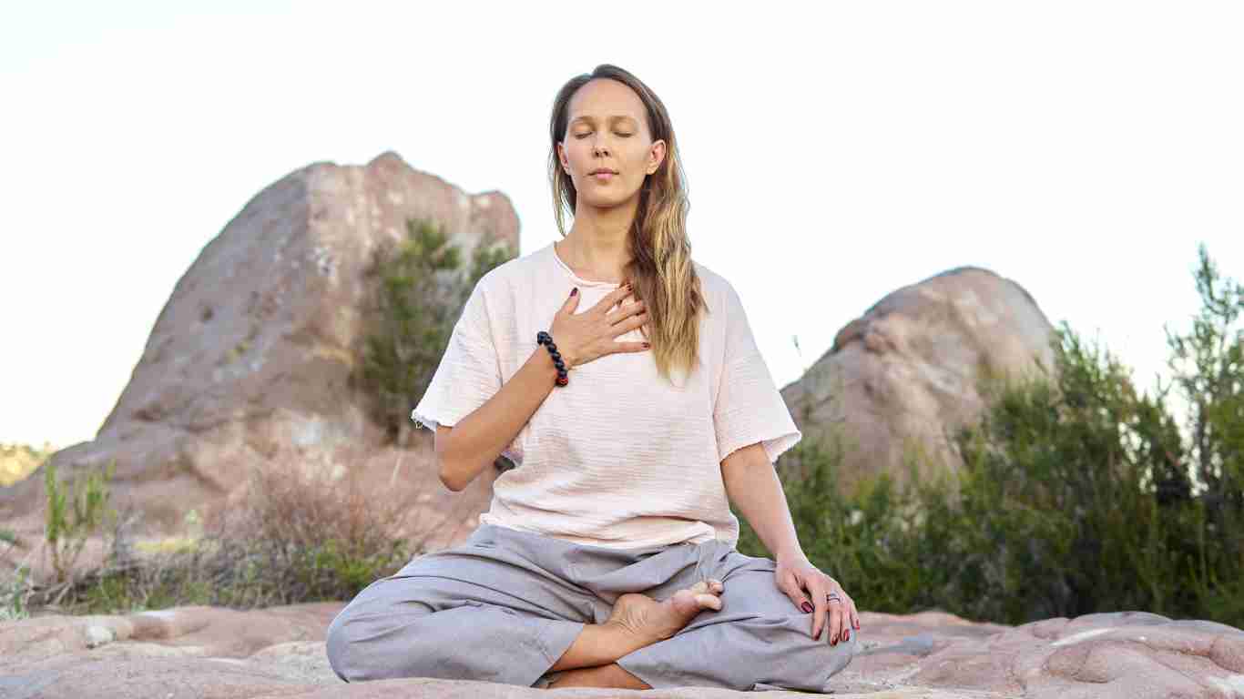 A woman meditating on the beach