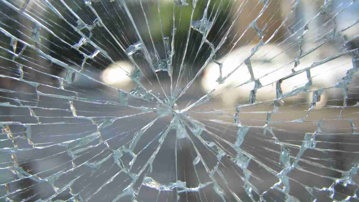 A shattered pane of glass, symbolizing broken trust