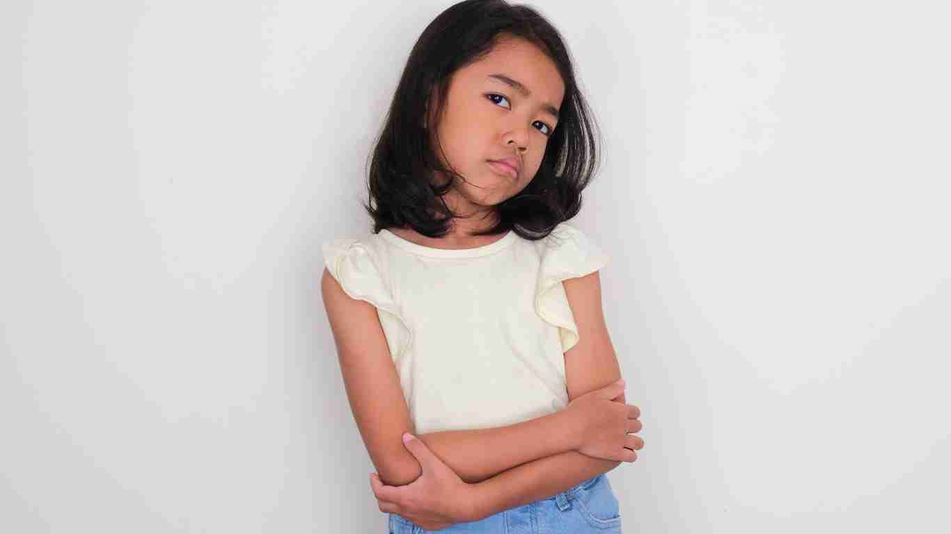 Sad little girl leaning against he wall