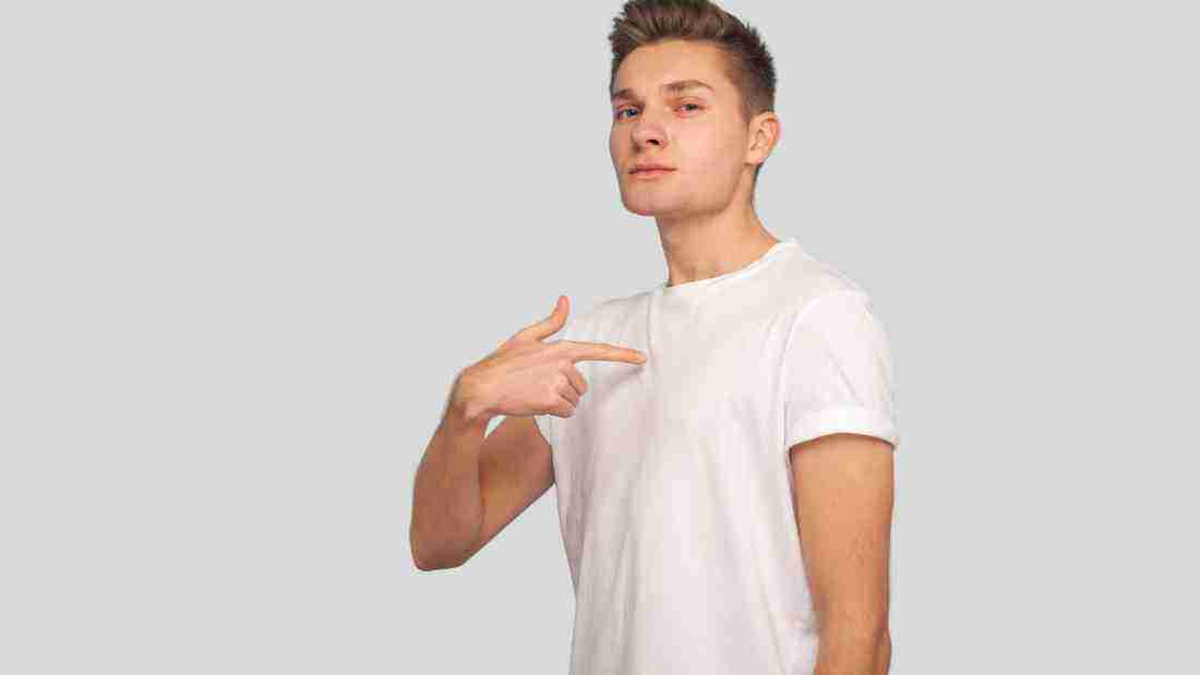 A man pointing to himself, signifying that he wants to be the centre of attention